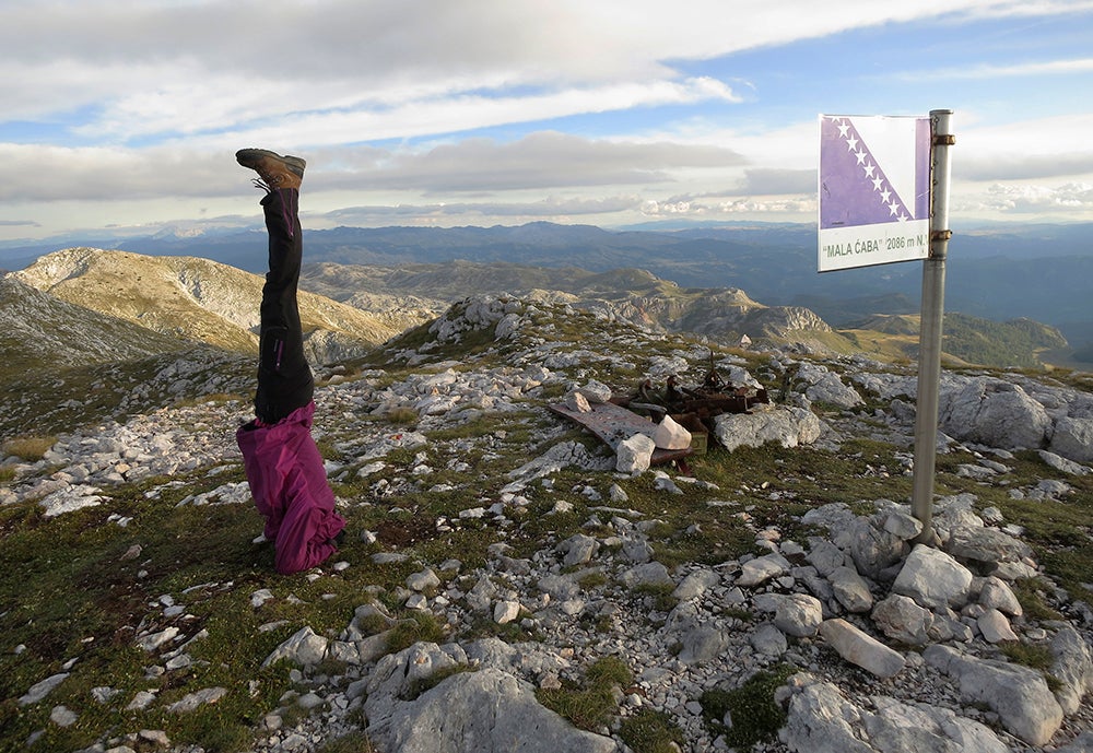 Mountaineer doing a headstand on the summit of Mala Caba or 'Djoko's Tower', Treskavica mountain, Bosnia and Herzegovina, photo by Elma Okic