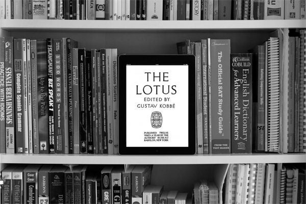 Tablet screen showing The Lotus Magazine on a book shelf with reference books.