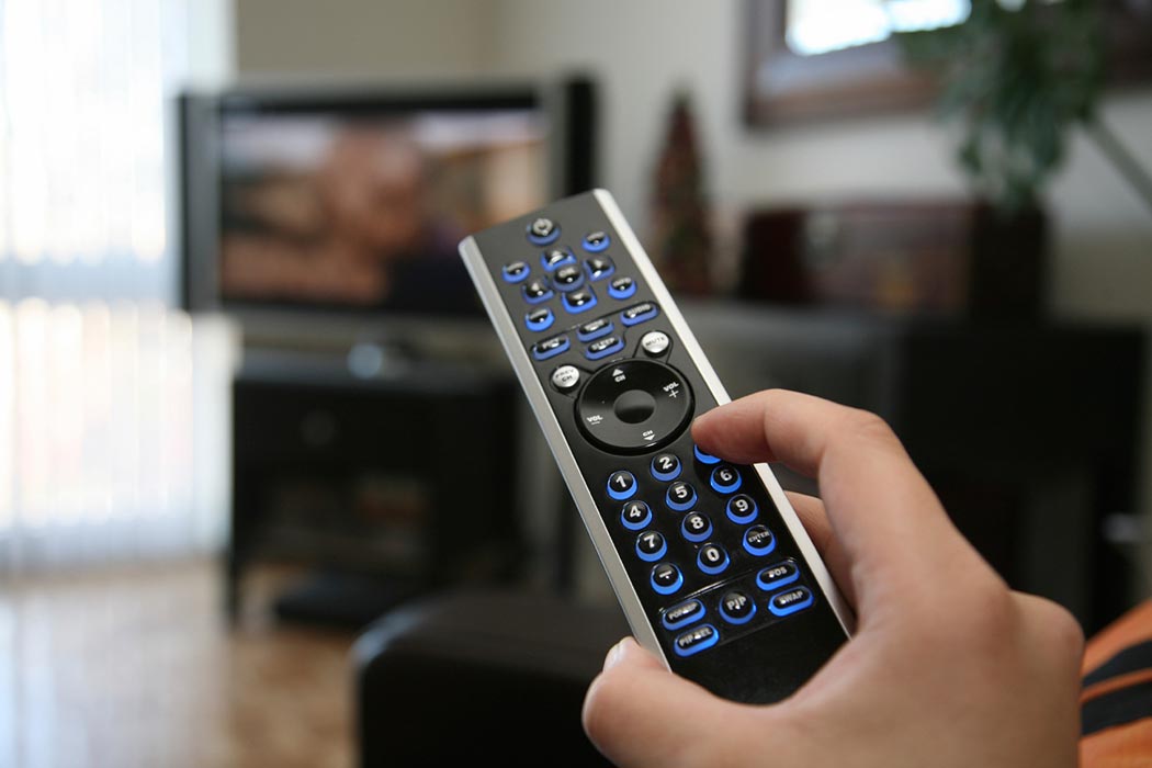 Close-up of a hand on a television remote control