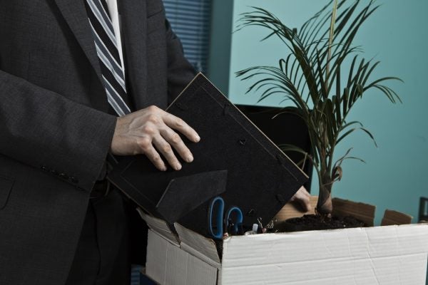 An office worker packing up the contents of their desk into a cardboard box