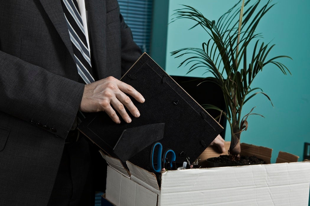 An office worker packing up the contents of their desk into a cardboard box