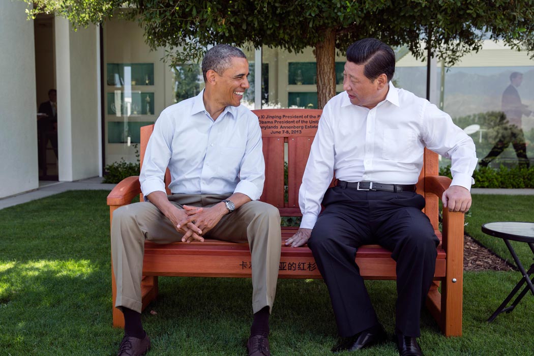 Former President Obama smiling on a bench beside Chinese President Xi Jinping