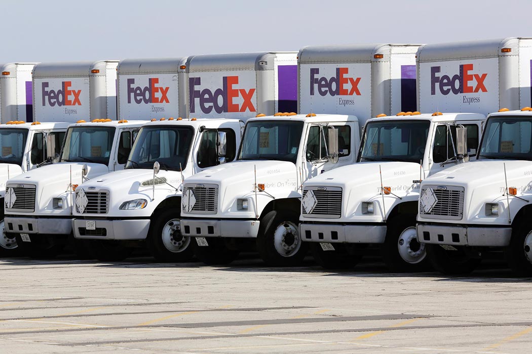 FedEx trucks lined up in a parking lot