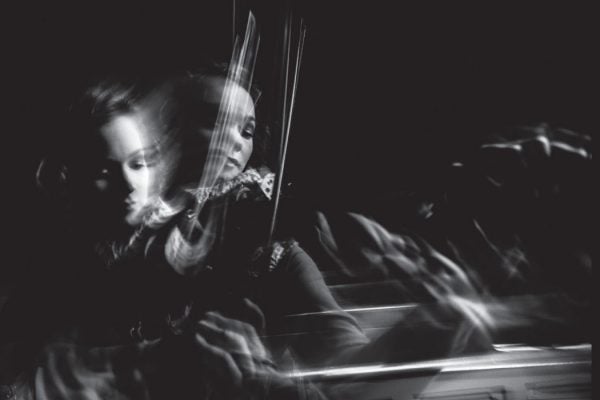 A female violinist captured in blurred and time-lapsed movement