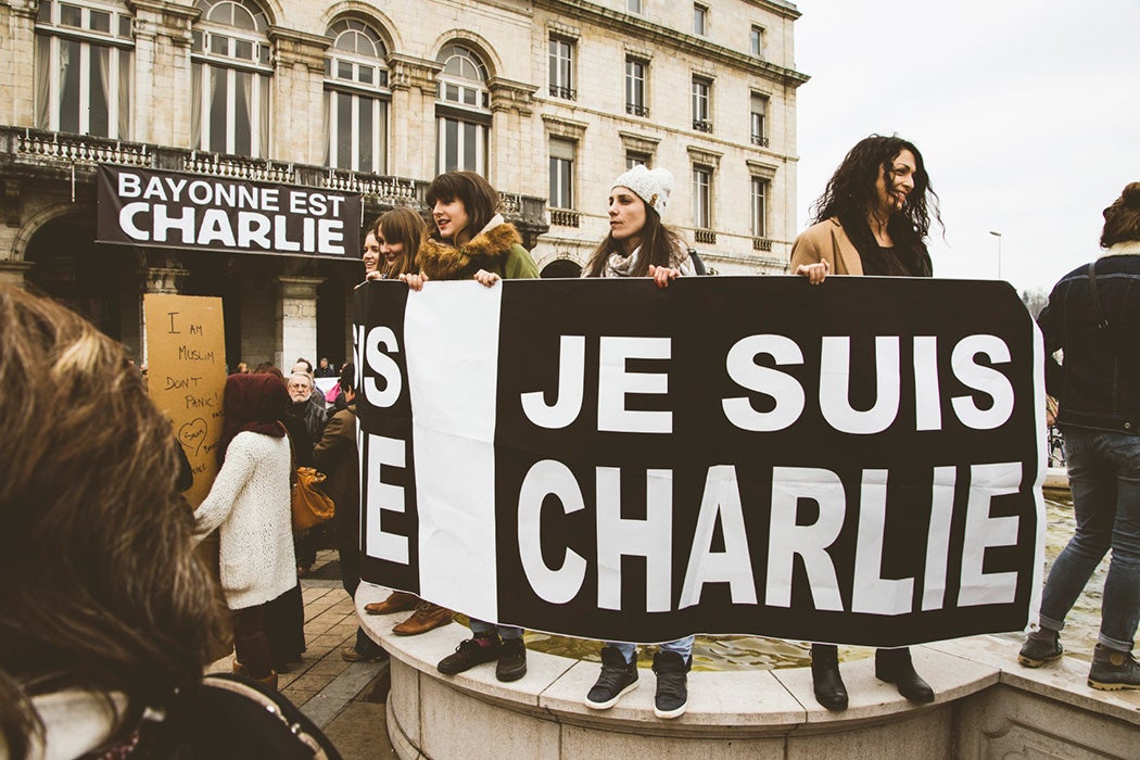 A group of protesters holding a large sign reading, "Je suis Charlie."