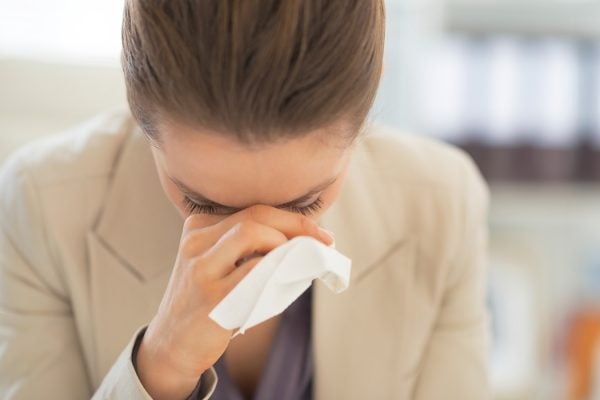 A woman clutches at a tissue and her sinuses