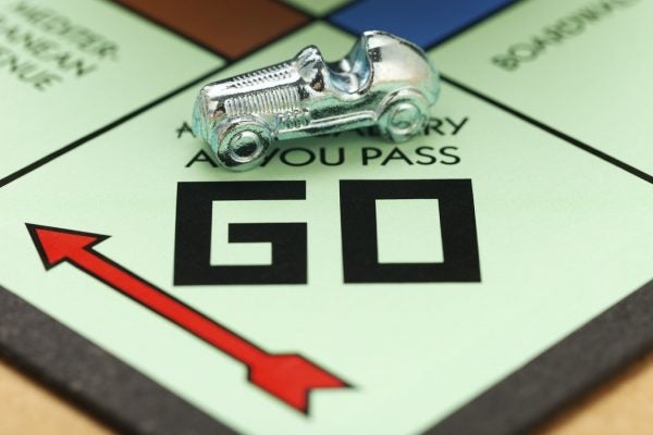 The car token at the starting square of the Monopoly board game