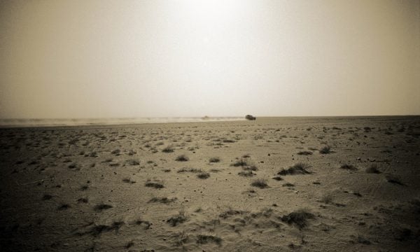A landscape of dust with sparse patches of grass