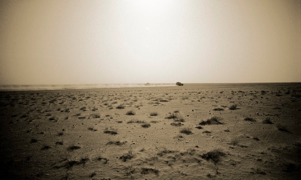 A landscape of dust with sparse patches of grass