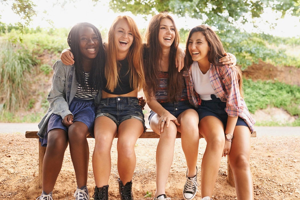 A group of friends laughing happily as they spend time outdoors in the sun