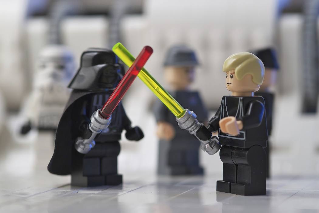Lego Luke Skywalker crossing light sabers with his father (aka Darth Vader)