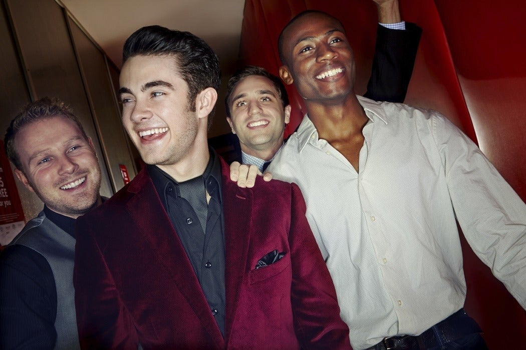 A group pf men smiling and arriving at a nightclub