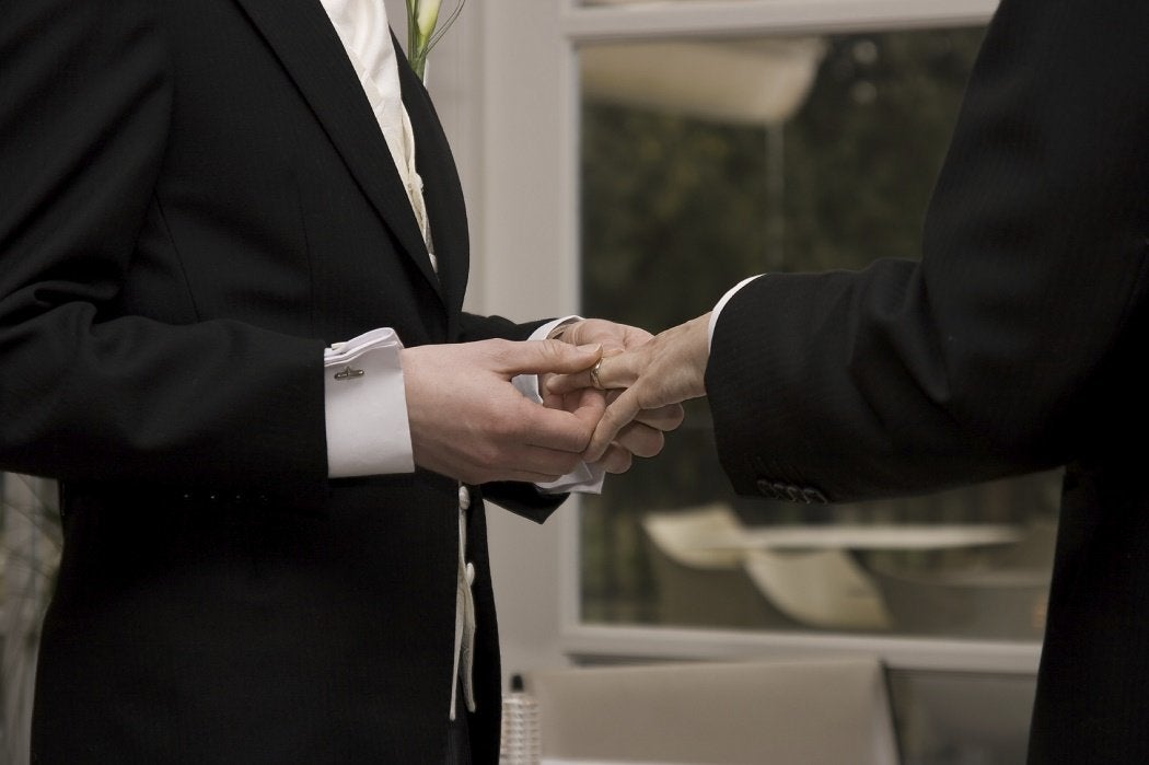 Two suited partners exchanging rings
