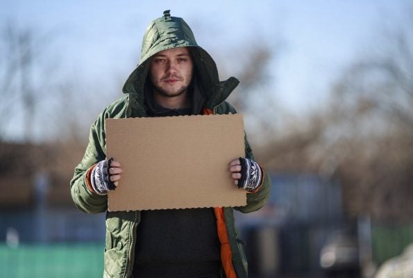 Homeless person with blank cardboard
