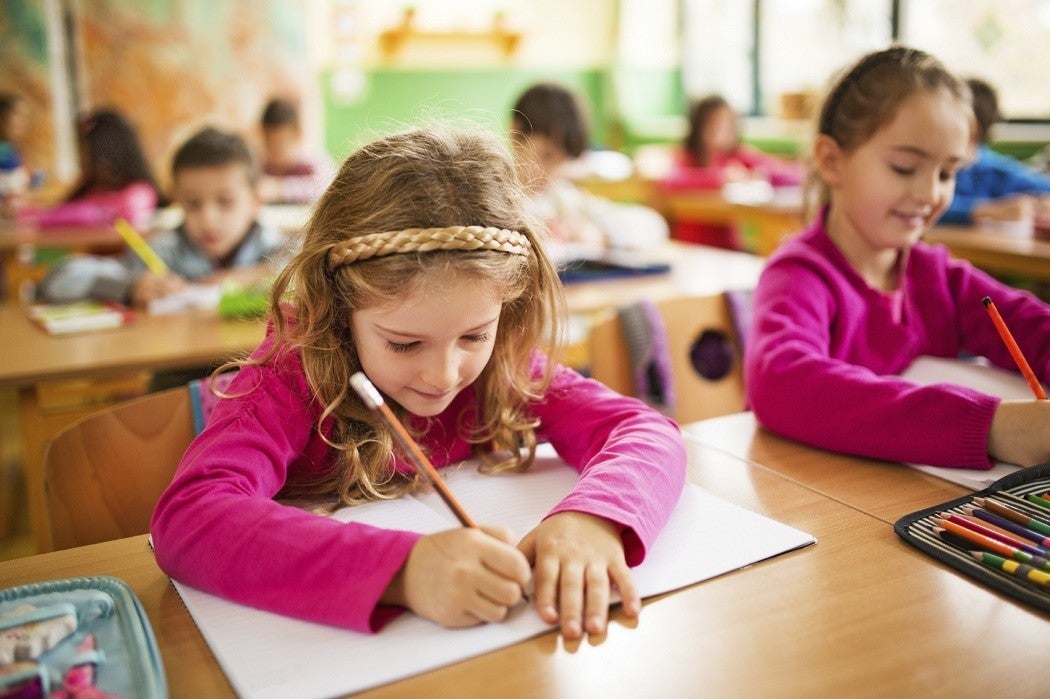 Schoolgirl writing in classroom.