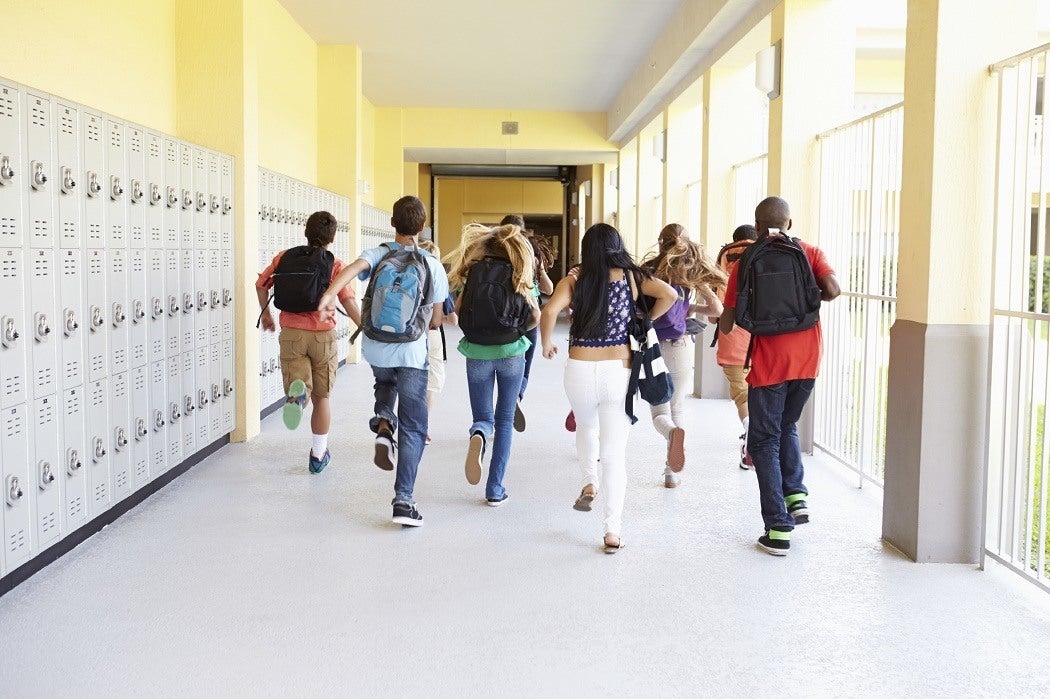 High school students run down the corridor of their school