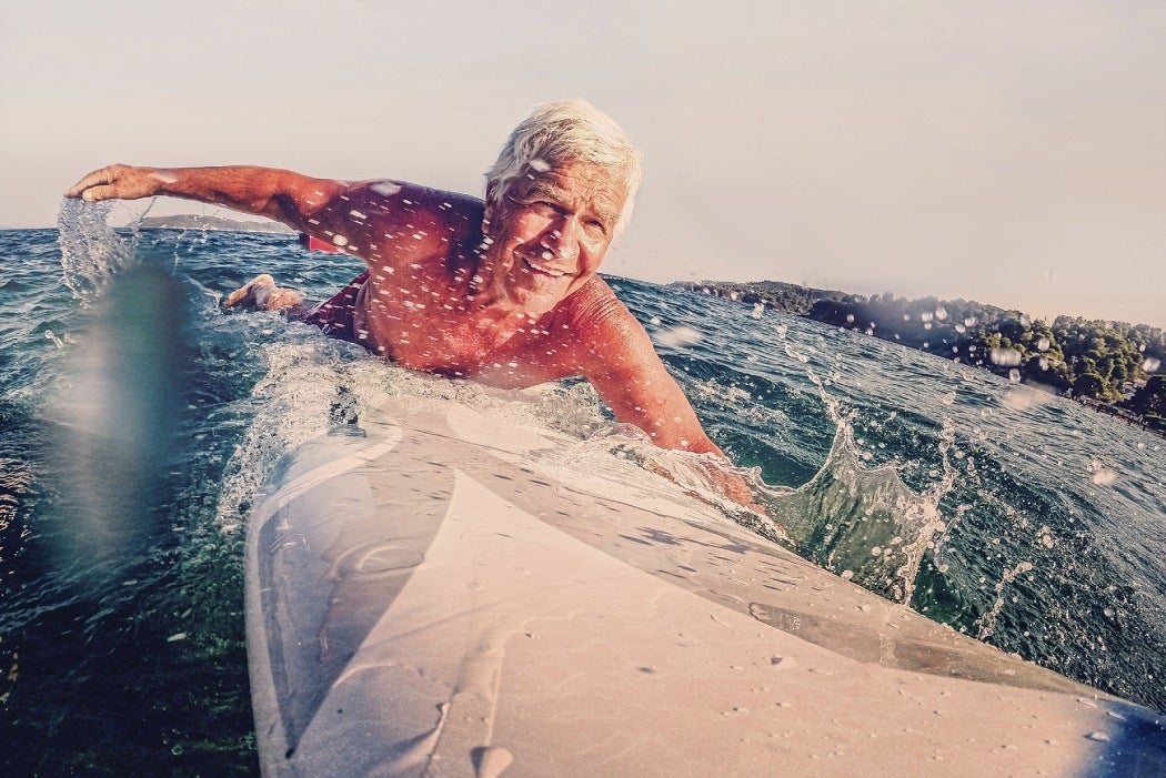 An older man catches a wave