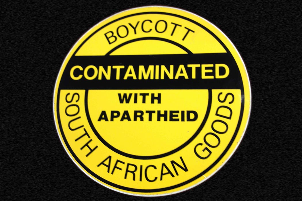 "Boycott - Contaminated with apartheid - South African goods" by Djembayz - Own work. Licensed under CC BY-SA 3.0 via Commons - https://commons.wikimedia.org/wiki/File:Boycott_-_Contaminated_with_apartheid_-_South_African_goods.jpg#/media/File:Boycott_-_Contaminated_with_apartheid_-_South_African_goods.jpg