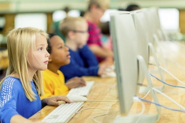 Second graders working on desktop computers