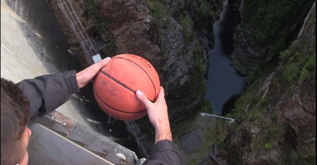 Young man holding a basketball over a ravine