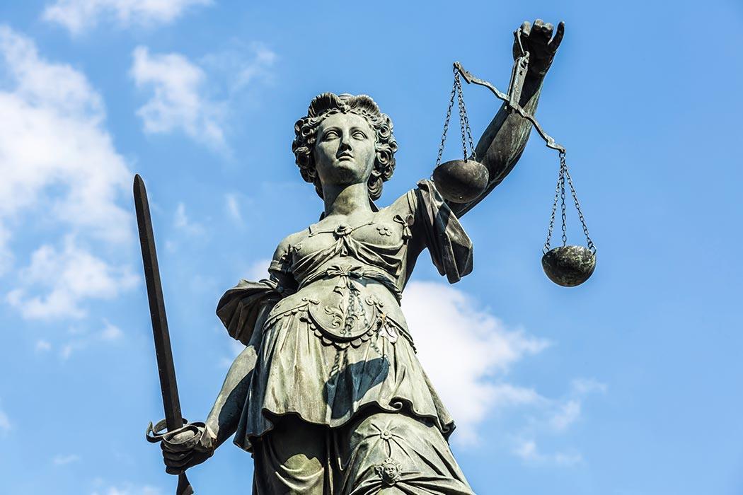 Statue of Lady Justice holding a sword in one hand and scales in the other