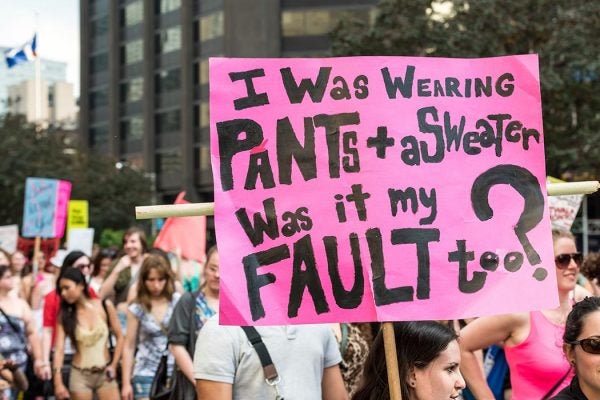 Toronto, Canada - May 25, 2012: A protest sign reading "I was wearing pants + a sweater, was it my fault too?" Taken during "Slut Walk 2012", a protest event about sexual assault and victims' rights, among other related issues.