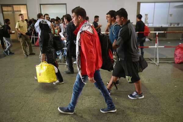 Migrants at Munich Hauptbahnhof main railway station return to a police holding area after a brief medical examination on August 29, 2015 in Munich, Germany.