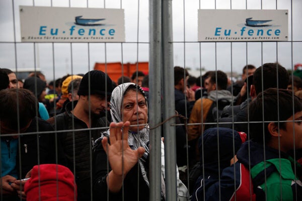 Migrants wait for a bus at a holding camp after Austrian authorities suspended train service due an overload of the train system at the Austrian border September 11, 2015 near Nickelsdorf, Austria.