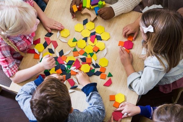 Children at preschool playing with colorful shapes.