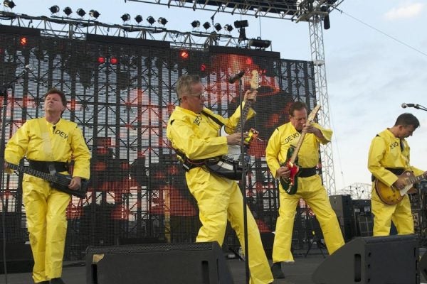 Devo onstage in their trademark bright yellow costumes.
