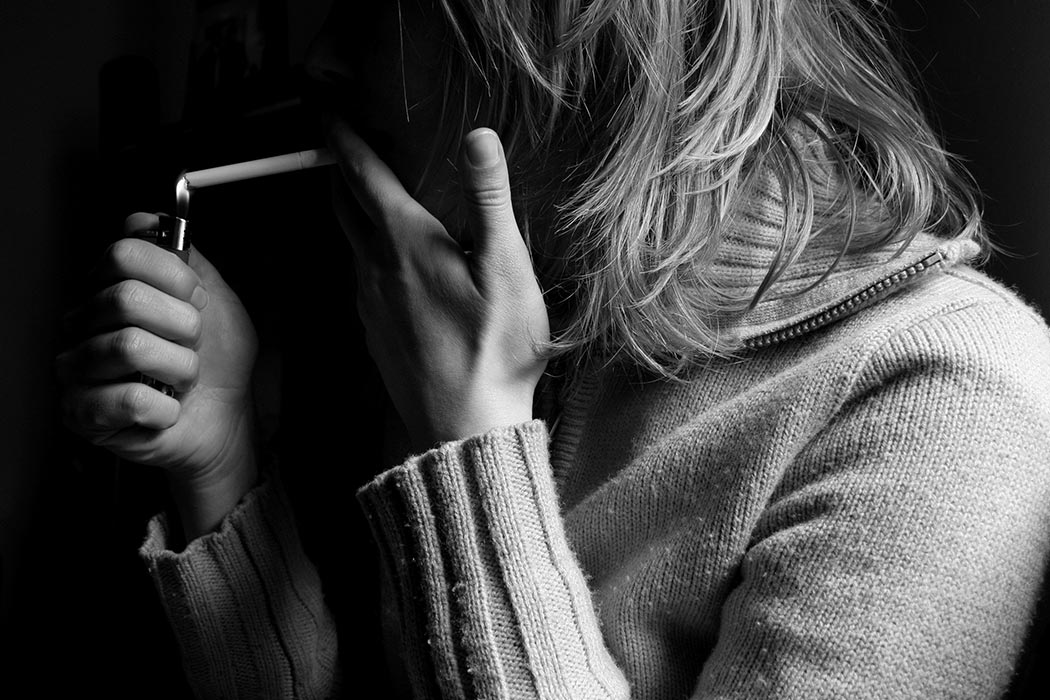 Woman lighting a cigarette.