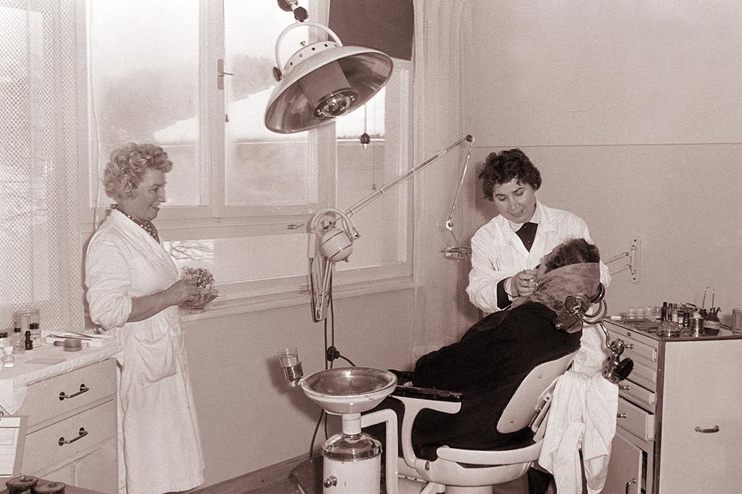 Female dentist with patient, 1960.