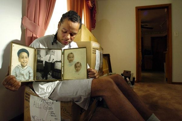 Abriel Thomas, a cousin of Emmett Till, holds a triptych showing childhood photos of Till in his Chicago home Monday, May 10, 2004, after news that federal authorities are reopening the investigation into the 14-year-old's 1955 race-motivated murder. "I wish Mamie could have been here," Thomas said. "It was the only thing she ever wanted out of life _ a little bit of justice." (AP Photo/Jeff Roberson)