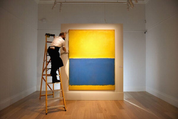 A gallery technician makes adjustments to the hanging of Mark Rothko's 'Untitled (Yellow and Blue), executed in 1954, as the work goes on show at Sotheby's on April 10, 2015 in London, England.