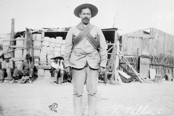 Francisco "Pancho" Villa (1877–1923), Mexican revolutionary general, wearing bandoliers in front of an insurgent camp. By Bain News Service, publisher.