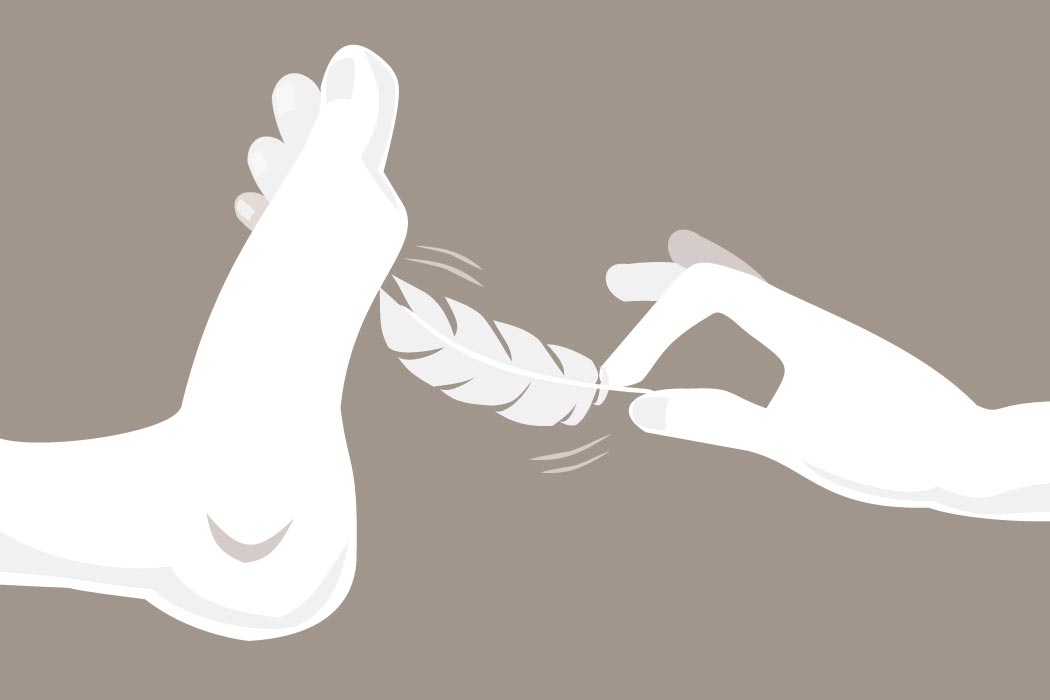 A hand tickling a foot with a feather