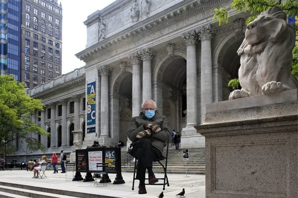 Bernie Sanders sitting in front of the New York Public Library with his mittens crossed