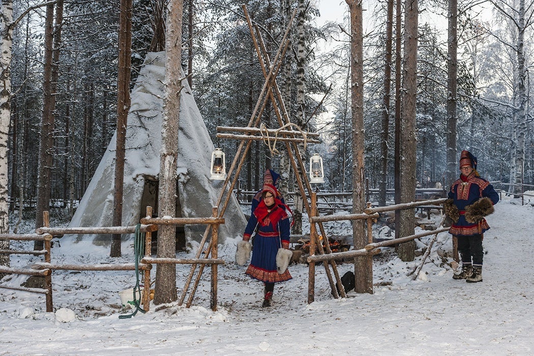 wo Sami people near their “lavvu”, a temporary dwelling similar to a Native American tipi.