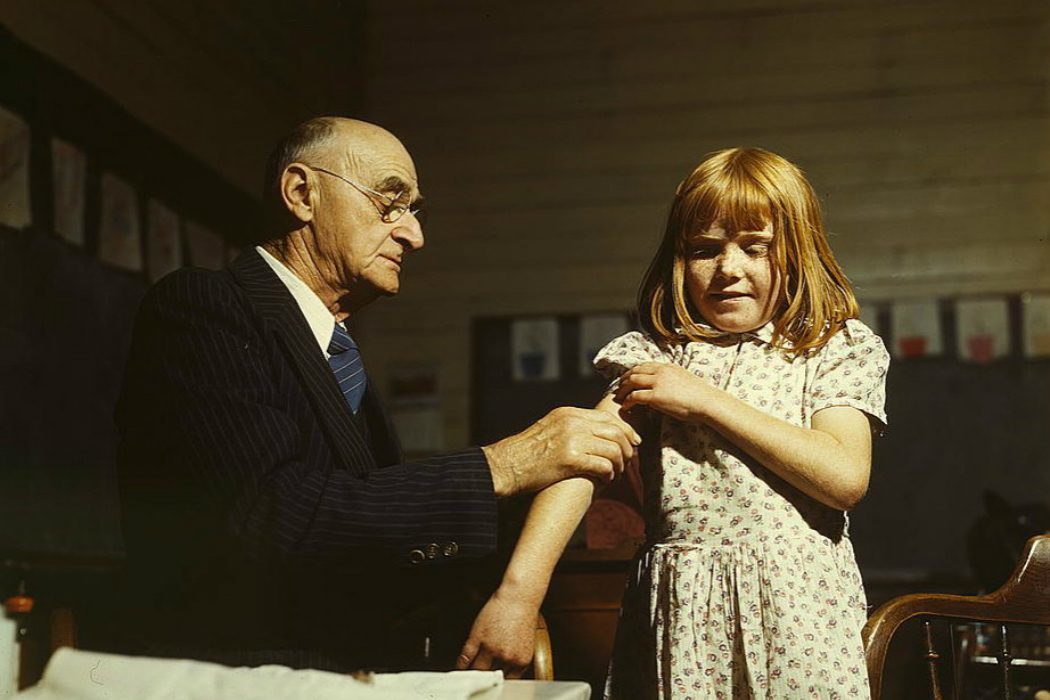 A doctor giving a young girl a vaccination
