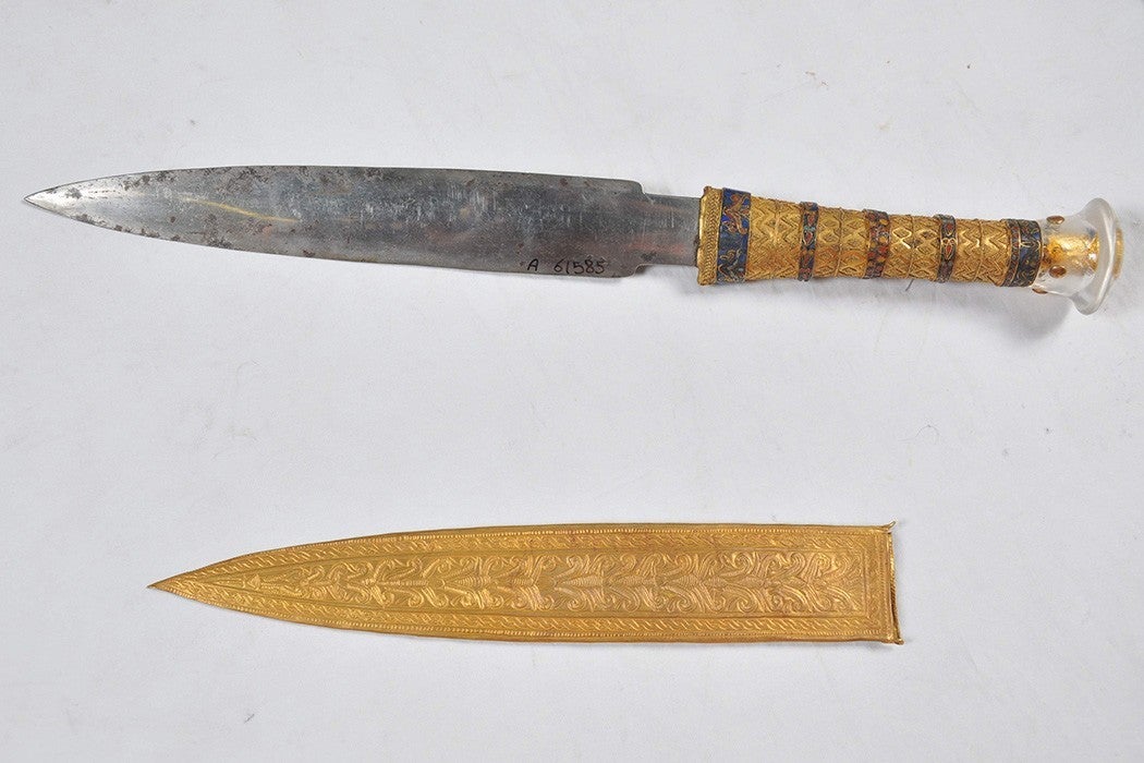 Unsheathed iron dagger with a golden hilt and sheath