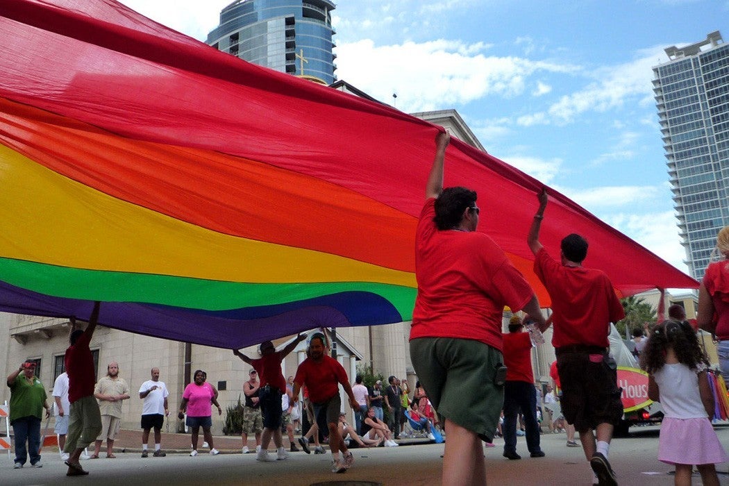 Parade goers carry a large rainbow flag at the Orlando Pride Parade