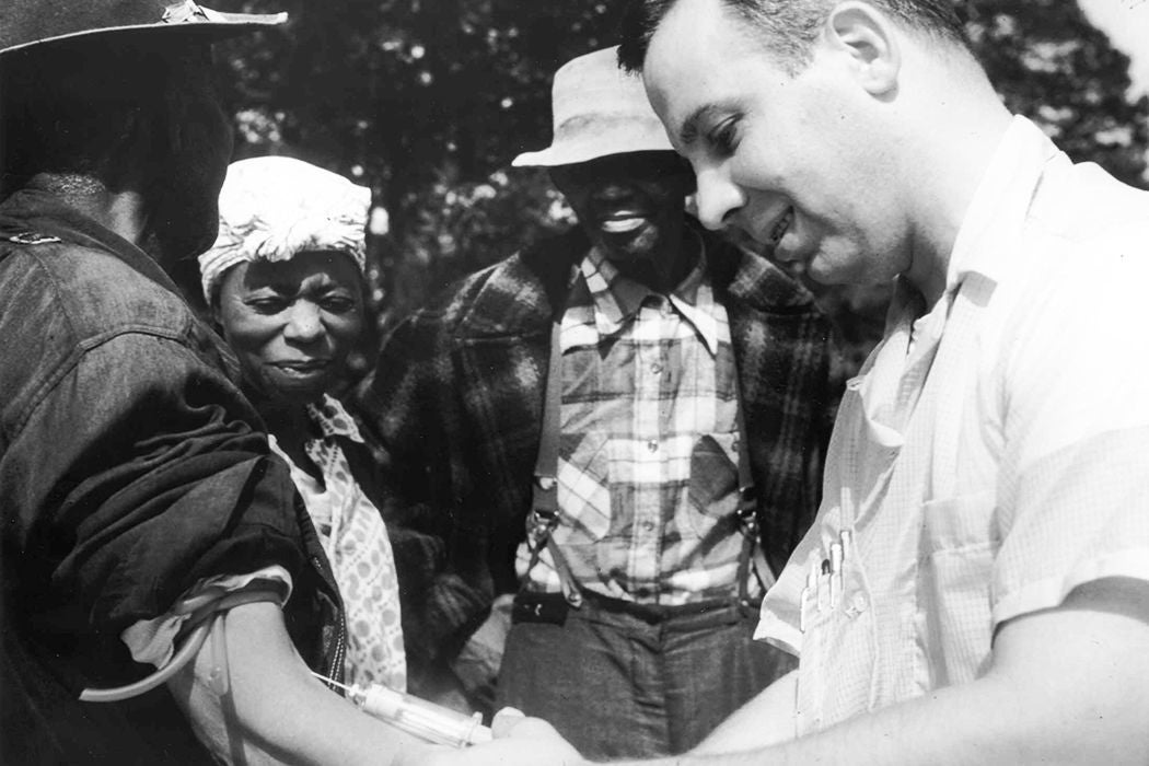 Dr. Walter Edmondson, doctor known for his participation in the Tuskegee Syphilis Study, taking a blood test from an unidentified patient