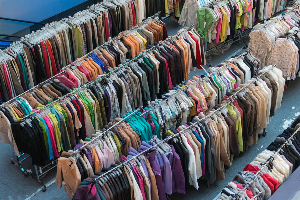 Crane shot of rows of full clothes racks with various styles, colors, and materials