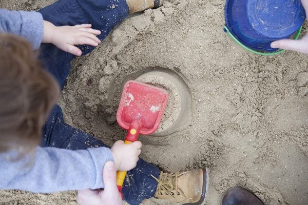 Toddler boy playing in sandbox