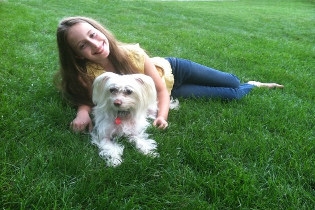 Girl and dog relaxing on a healthy green lawn
