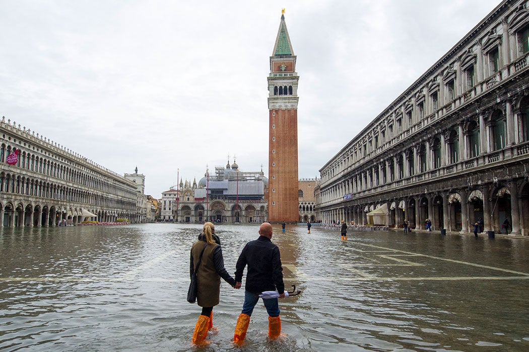 Venice, Italy with flooding and tourists walking in high water