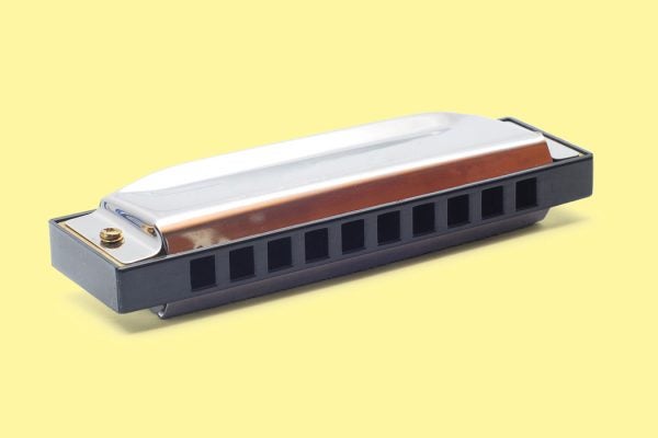 A harmonica against a yellow background