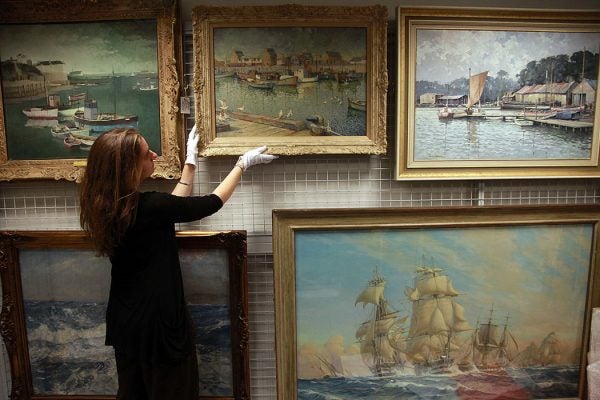 An assistant curator at the National Maritime Museum Cornwall inspects a rare painting that is currently being kept at the museum store and warehouse