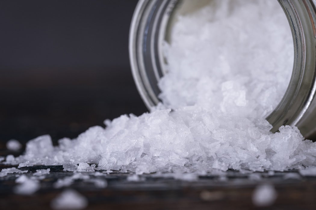 Flakes of sea salt spilling out of a jar