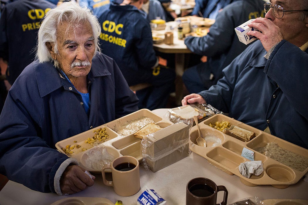 Anthony Alvarez (L), age 82, eats breakfast with Phillip Burdick, a fellow prisoner and member of the Gold Coats program at California Men's Colony prison on December 19, 2013 in San Luis Obispo, California. 